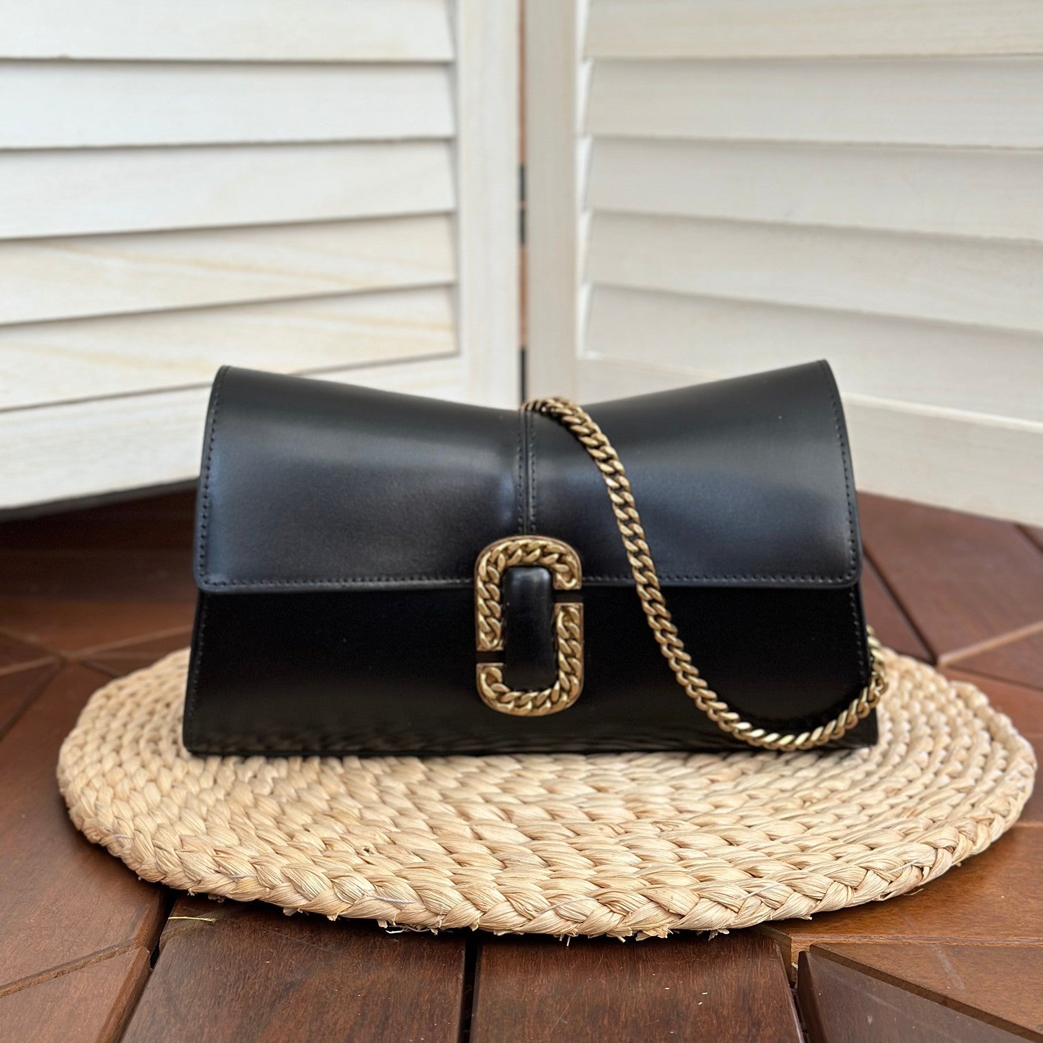 Black leather shoulder bag with gold-tone chain strap and statement buckle detail – a bold and elegant accessory for any occasion
