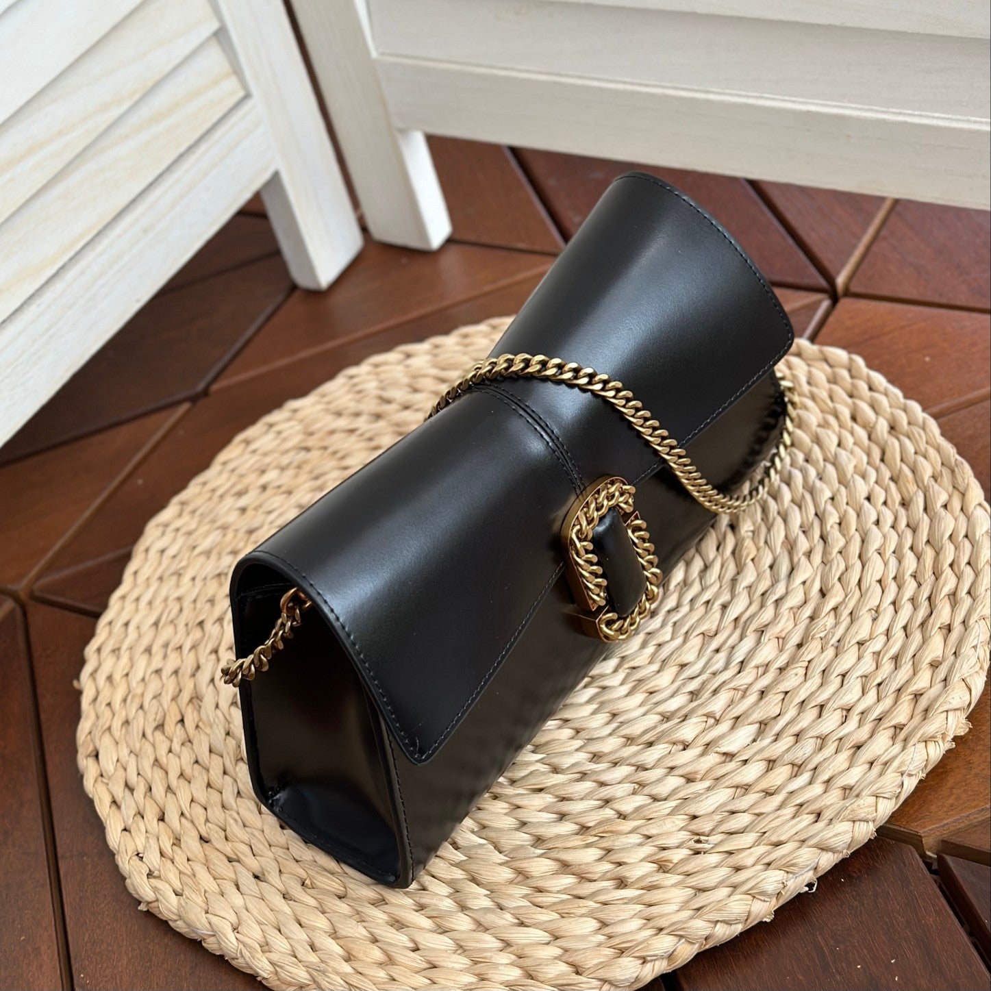 Black leather shoulder bag with gold-tone chain strap and statement buckle detail – a bold and elegant accessory for any occasion