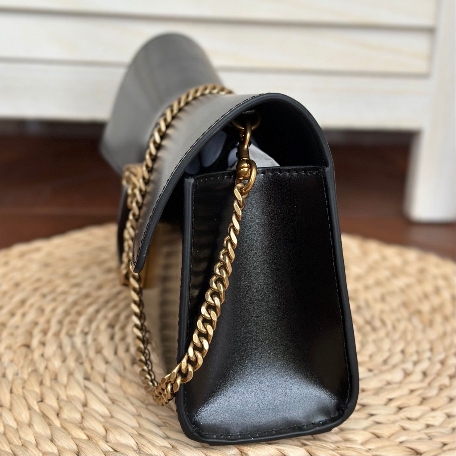  Black leather shoulder bag with gold-tone chain strap and statement buckle detail – a bold and elegant accessory for any occasion