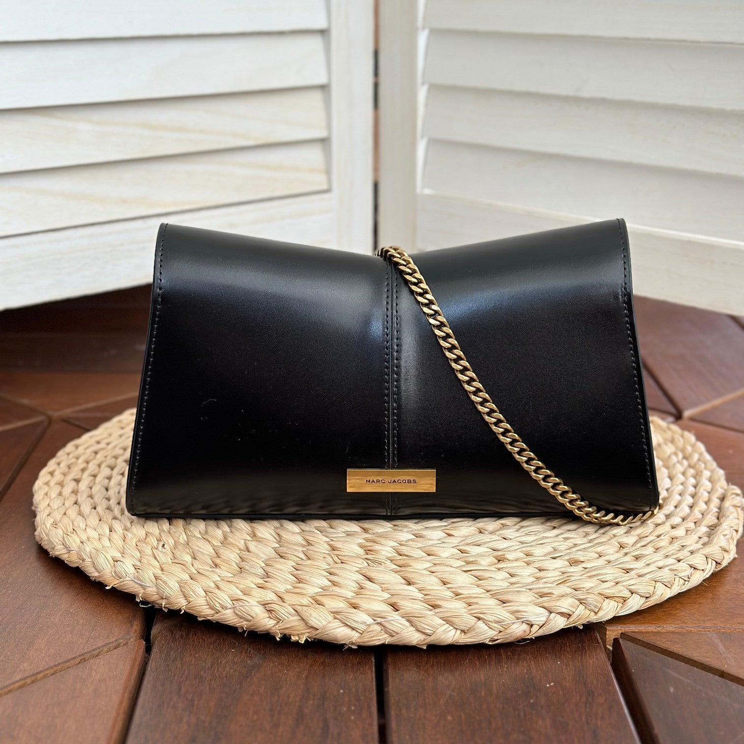  Black leather shoulder bag with gold-tone chain strap and statement buckle detail – a bold and elegant accessory for any occasion