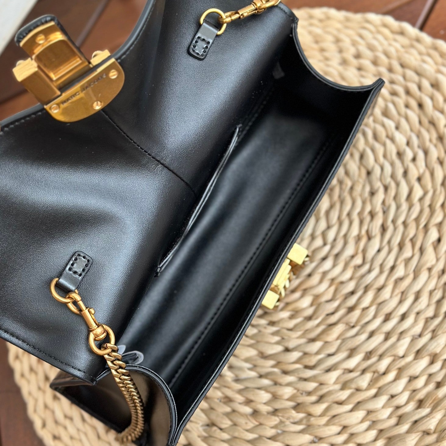  Black leather shoulder bag with gold-tone chain strap and statement buckle detail – a bold and elegant accessory for any occasion
