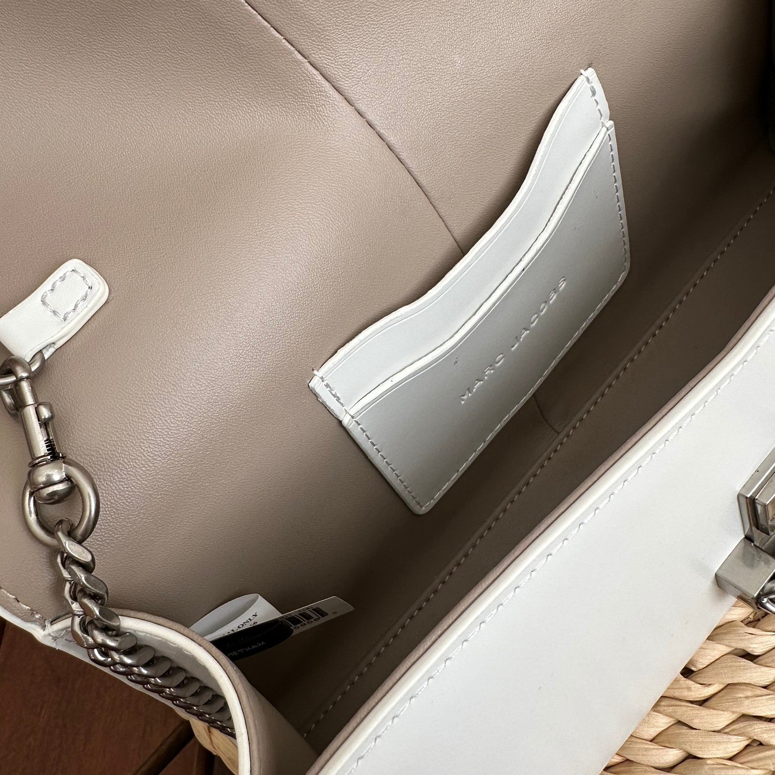 White leather shoulder bag with silver-tone chain strap and interwoven buckle – a modern luxury accessory for any occasio