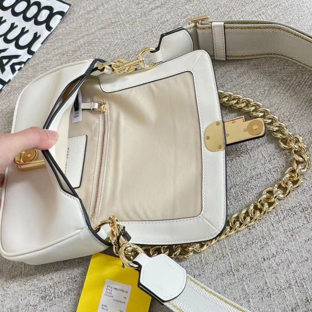 Ivory leather shoulder bag with gold-tone chain, adjustable fabric strap, and statement buckle – a modern minimalist handbag for every occasion