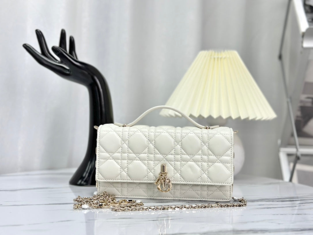 Luxury ivory lambskin shoulder bag with quilted design, gold-tone chain strap, and iconic logo—perfect for timeless elegance.